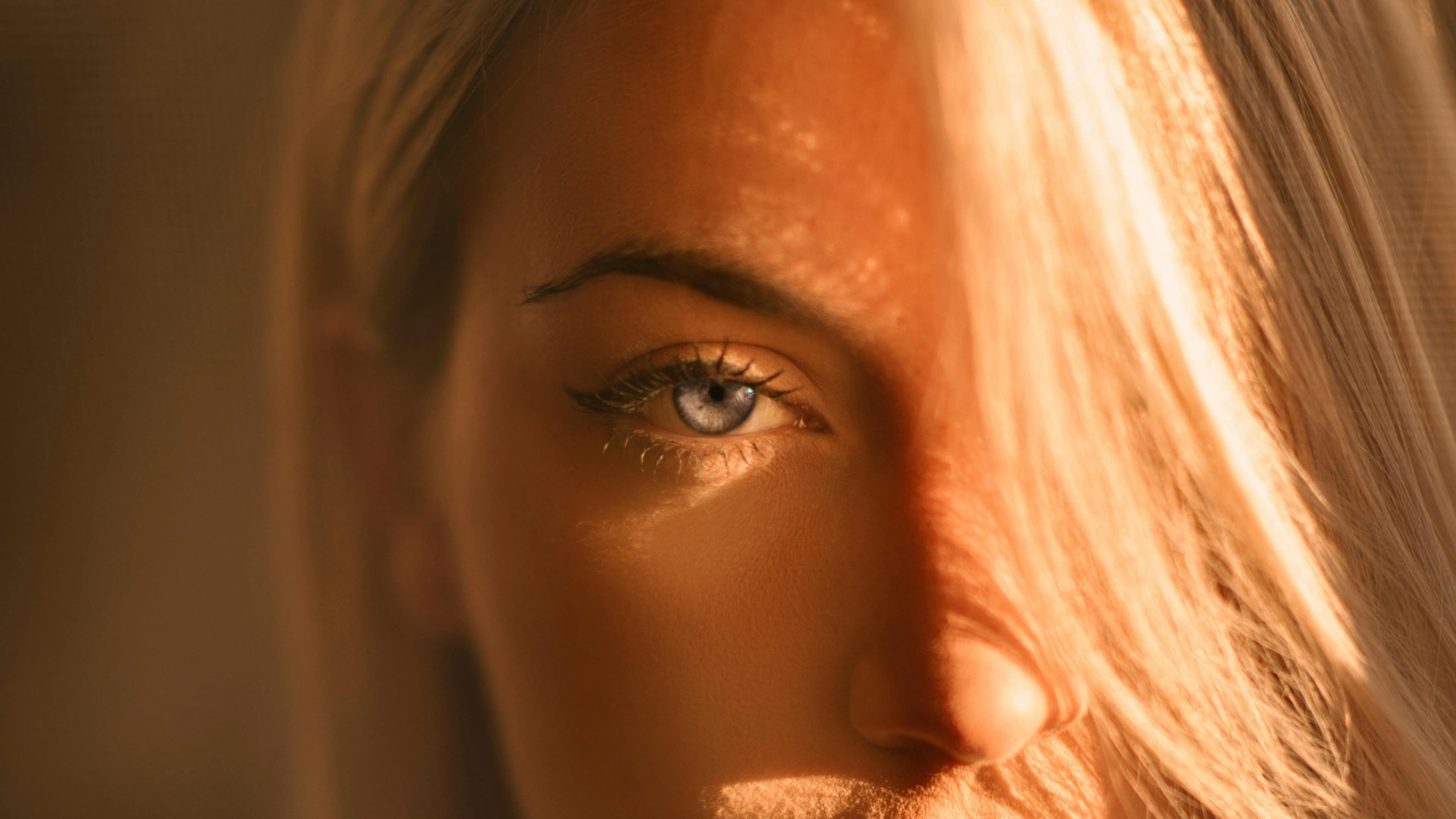 Detailed close-up of a woman’s eye in warm light